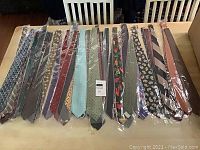 First photo showing a wide array of men's dress ties laid out with various colors and patterns, all individually packaged in plastic.