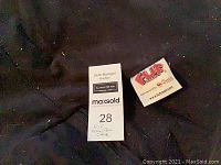 Close-up photo showing the FUF brand tag on the bean bag chair fabric and auction lot number.