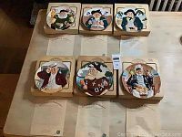 Six Toby Fillpot collector plates by Davenport Pottery with original boxes and Certificates of Provenance displayed on table.