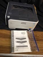Brother HL-2170W laser printer shown with quick setup guide and toner supplies in clear plastic bag