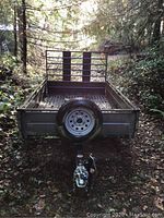 Front view showing spare tire mounted on front panel and ball coupler hitch