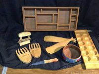 Photo of entire set showing all wooden utensils, box, bowl, and knife arranged on a dark surface.