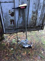 Full view of Silvertrol boat motor showing long metal shaft, propeller, and attached cord.