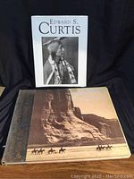 Front covers and spine of two books about Edward S. Curtis, showing cover image of Native American figures on horseback and a portrait photo book cover.