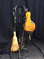Front view of the entire fireplace tool set including stand, tools, and bellows.
