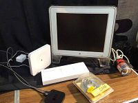 Apple Studio Display monitor with stand, Apple TV device, Apple Wireless Keyboard, Wink hub device, and power adapter.