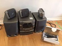 Front view of Pioneer stereo system main unit flanked by two large speakers with three small speakers on top and microphone box on the floor