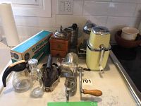 Wide shot showing entire kitchen appliance and tool lot on counter.