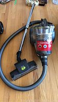 Full view of Hoover vacuum cleaner showing main canister, hose, wand and brush head on floor