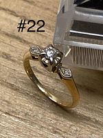 Front perspective on wood surface showing center diamond and shoulder accents with “#22” label in frame