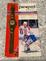 Front view of the watch in original packaging with signed photo and branding