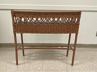 Front view of brown wicker planter on stand