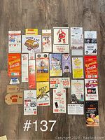 Overall view of Coca Cola vintage paper advertising pieces laid out in grid format on floor.