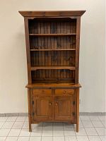 Front view of closed pine cabinet bookshelf showing three shelves, two drawers and closed lower doors
