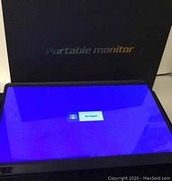 Portable monitor turned on, showing 'No Signal' message on screen.