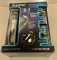 Front packaging showing Kemei 5 in 1 full care grooming kit Model KM-7933 USB with product information and visible trimmer unit and attachments.
