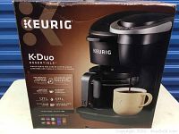 Box of Keurig K-Duo Essentials coffee maker showing product photo and features.