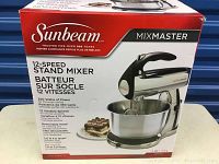 Photo of product box showing Sunbeam MixMaster 12-speed stand mixer details including power, bowl capacity, and features.