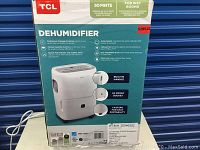 Box showing TCL branding and product features for 50 pint dehumidifier suitable for wet rooms.