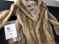 Full front view of mink coat laid flat showing overall condition and style