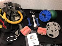 Photo of the workout accessories including handweights, ab wheel, plate weights, exercise ball and rings