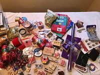 Overview of large assortment of Christmas crafting supplies including ribbons, stamps, ink pads, embellishments
