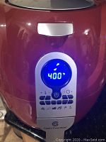 Front view of large red air fryer with digital control panel showing temperature set to 400°F and multiple function buttons.