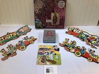 Lot overview showing the Disney themed wooden train puzzles, Cinderella limited edition set, and Hannah Montana scrapbook in original packaging.