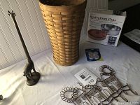 Wide shot of the lot showing Longaberger basket, giraffe toilet tissue holder, springform pan box, felt pads, and kitchen keyholder.