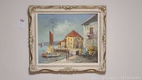 Framed acrylic painting showing a coastal scene with a boat, buildings and water in soft colors