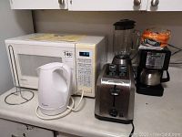Kenmore microwave oven, Superior upright kettle, Black and Decker blender, Sunbeam coffee maker with bread loaf on top