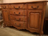 Front view showing drawers, doors, scalloped skirt, brass pulls and hinges