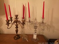 Both candelabras shown together with red and white candles inserted, showing overall height and style.