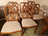 Six wooden dining chairs shown together, highlighting shield back design and upholstered seats.