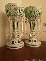 Front view of both mantle lusters showing overall shape, enamel decoration and prism drops