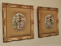Overall view of both framed bisque relief sculptures next to each other on wall to show size and style.