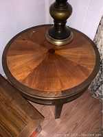 Top view of one circular end table showing wood veneer pattern and minor surface nicks.