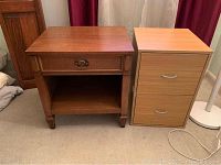 Front view of the wooden Missouri Masterpiece nightstand and the wooden file cabinet side by side on carpet.