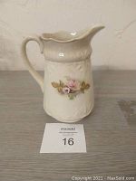 Front view of vintage off-white ceramic pitcher jug with pink flower decoration