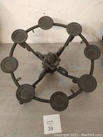 Top-down view of the circular black metal candle holder with eight round holders and a floral centerpiece.