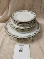 Stack of 12 plates showing size differences and floral patterned borders.