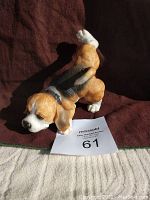 Side and top view of the vintage Beagle figurine placed on a brown cloth with a lot number card.