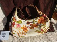 Front view of the floral pattern shoulder purse with brown leather accents, showing the main body and strap.