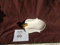 Top view of small white swan-shaped dish with gold neck and beak, showing size relative to paper marker with lot number 69
