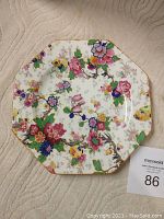 Top view of the octagonal floral decal plate showing detailed multicolor floral pattern and scalloped edges.