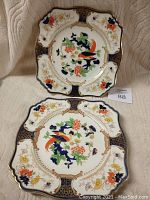 Two decorative Royal Winton Grimwades Westminster patterned plates displayed front-facing to show detailed colorful bird and floral designs with gold accents.