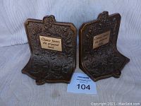 Front view of both cast iron bookends showing floral design and quote plaques
