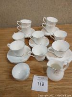 10 Royal Doulton teacups, saucers, cream and sugar set arranged together