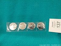 Front side of the set of four Star Wars New Hope medallions sealed in plastic, showing character reliefs.