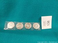 Front sides of four Star Wars Revenge of the Sith coins in a plastic sleeve, showing different embossed character and symbol designs.